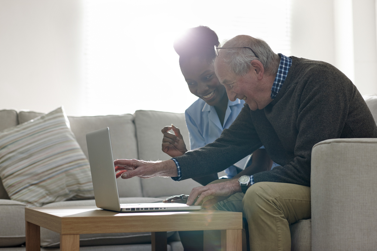nurse and elderly person with laptop